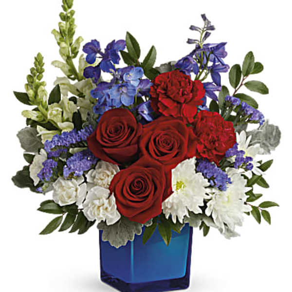 Red roses and mixed blue-white flowers in a blue glass vase