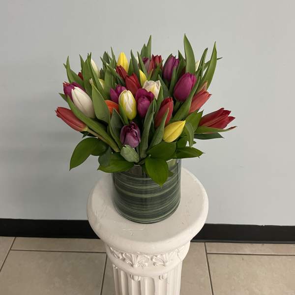 Colorful tulip bouquet in a striped glass vase