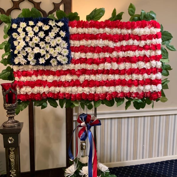 Floral American flag standing spray with red, white, and blue flowers