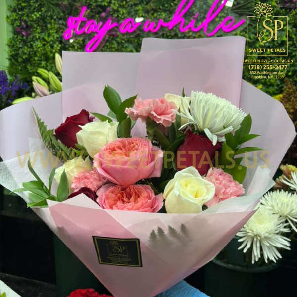 Pink and white rose bouquet wrapped in pale pink paper