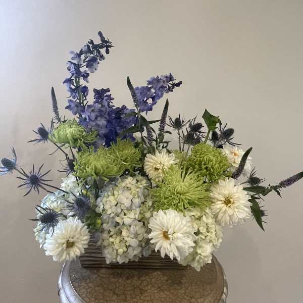 Mixed bouquet with white and green blooms in a low container