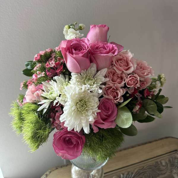 Pink roses and white chrysanthemums arranged in a glass vase