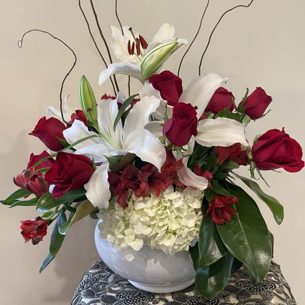 Red roses and white lilies arranged in a white vase