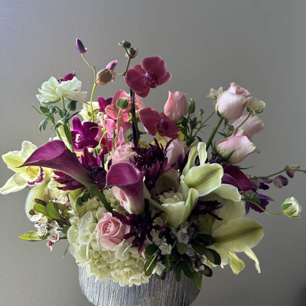 Mixed bouquet in a silver vase with pink, white, and purple blooms