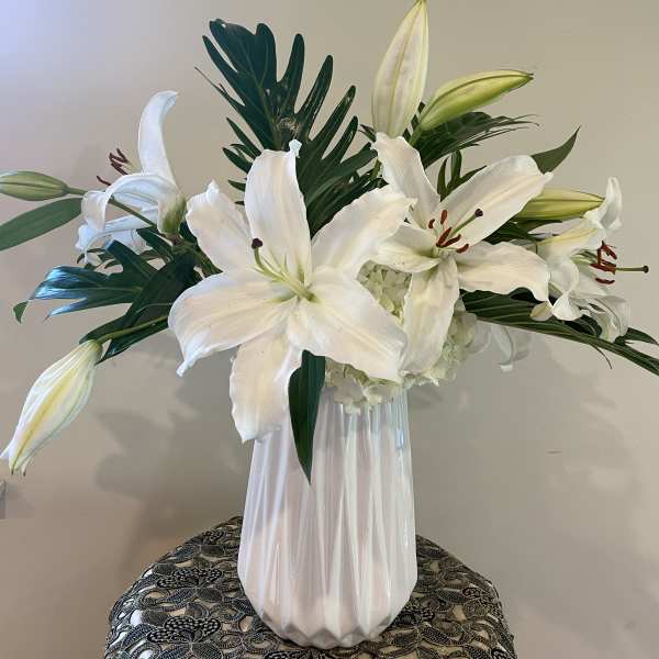 White lilies arranged in a clear glass vase