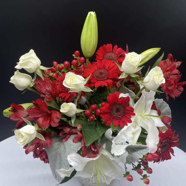 Red gerberas and white roses in a white vase