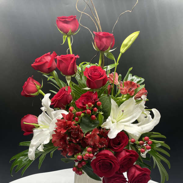 Red roses and white lilies arranged in a white vase