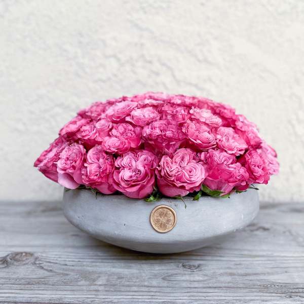 Pink roses arranged in a low gray bowl vase