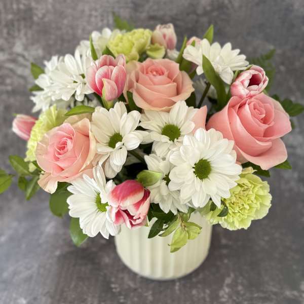Pink roses and white daisies in a white vase