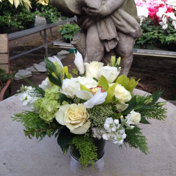 White and green floral arrangement in a clear vase