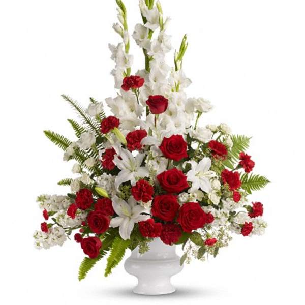 Tall red and white floral arrangement in a white vase