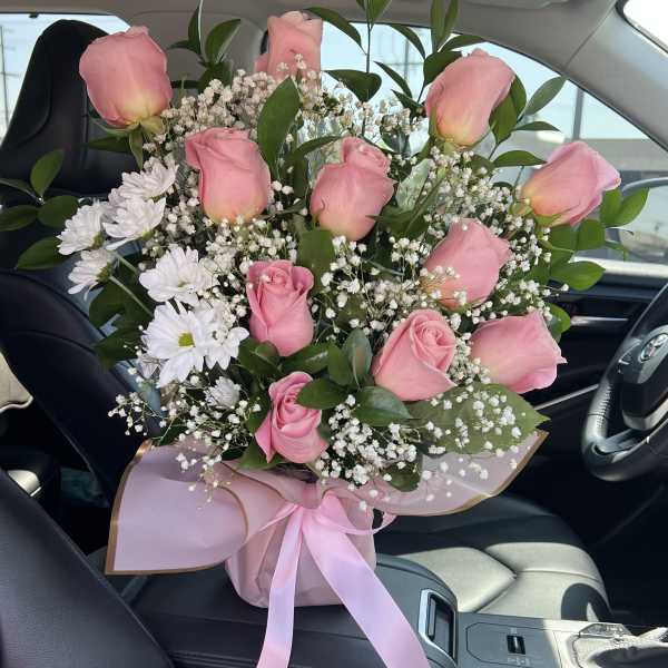 Pink roses and white daisies in a wrapped bouquet