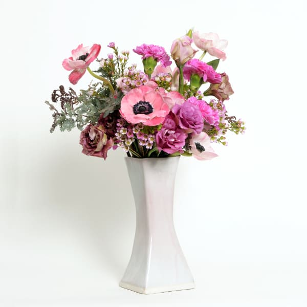 Pink and purple flower arrangement in a white vase