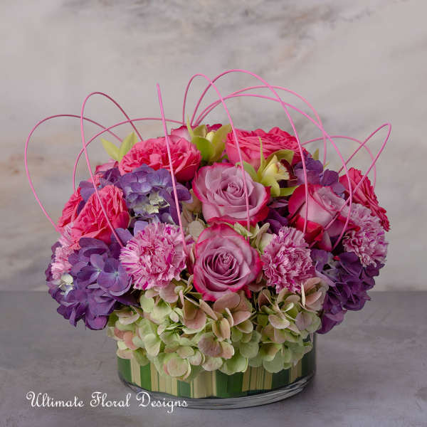 Pink and purple roses with hydrangeas in a glass vase