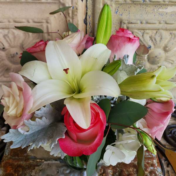 Bouquet of white lilies and pink roses in a glass vase