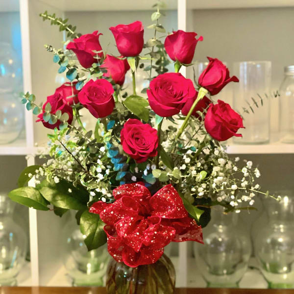 Bouquet of red roses in a glass vase with a red ribbon