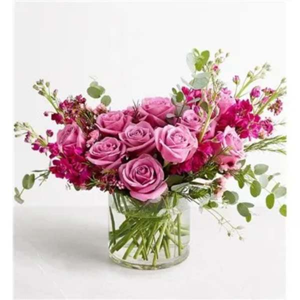 Pink roses in a clear glass vase with airy filler flowers