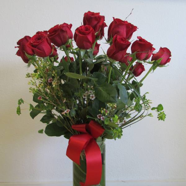 Bouquet of red roses in a glass vase with a red ribbon