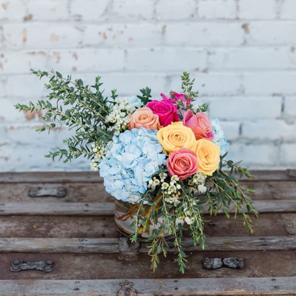 Bouquet of pastel roses and blue hydrangea in a glass vase