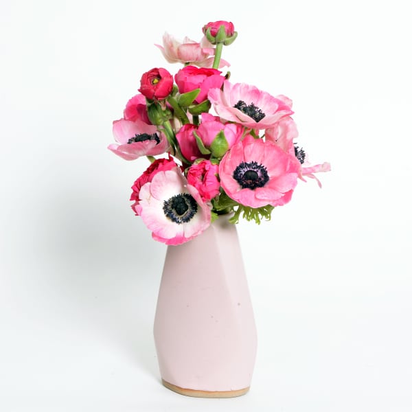 Pink anemones arranged in a pale pink vase