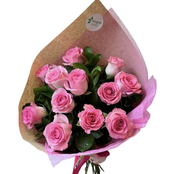 Bouquet of pink roses wrapped in brown and pink paper with a pink ribbon tie
