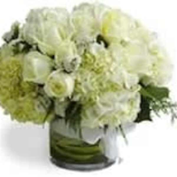 White and pale green floral arrangement in a glass vase