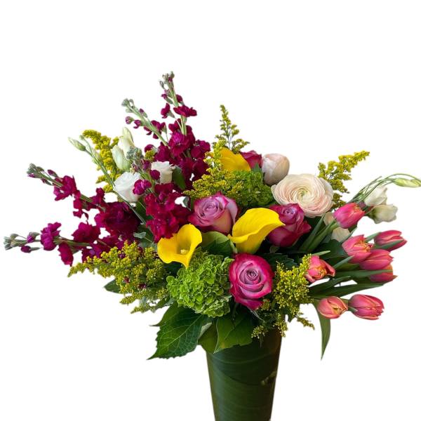 Mixed bouquet with pink roses, yellow calla lilies, and magenta flowers in a glass vase