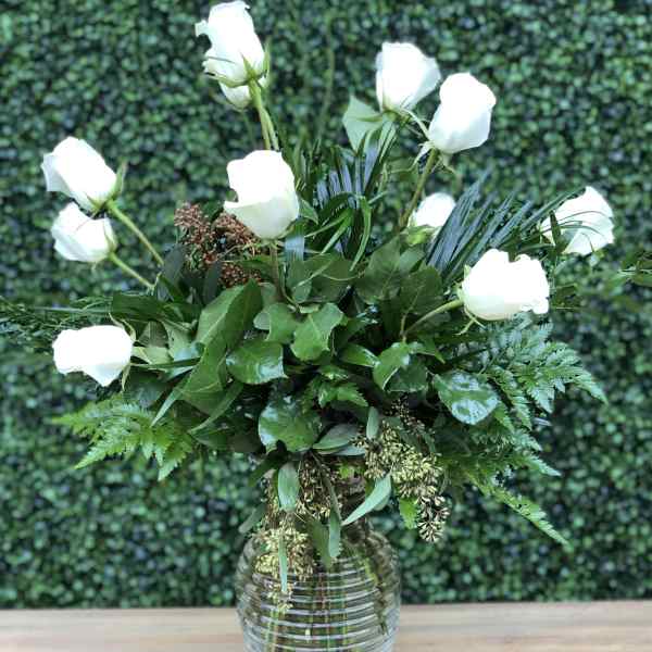White roses arranged in a clear glass vase
