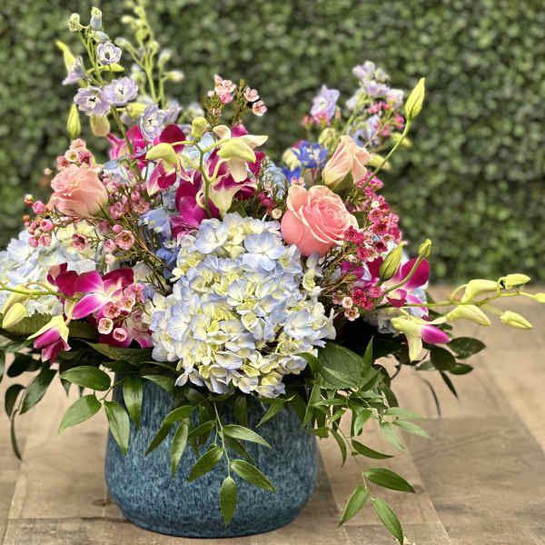 Colorful mixed flower arrangement in a blue vase