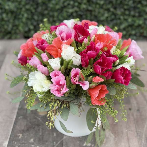 Colorful bouquet of carnations in a white vase