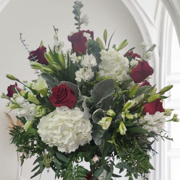 Bouquet of red roses and white hydrangeas in a glass vase