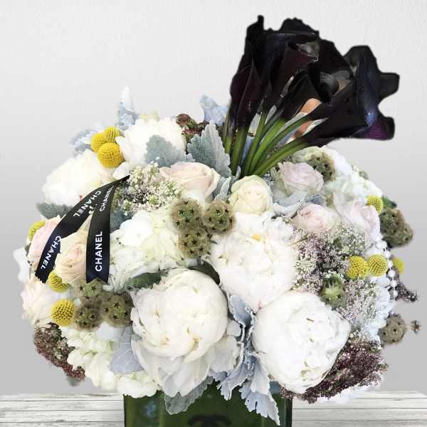 White and pale pink bouquet with black calla lilies in a green vase