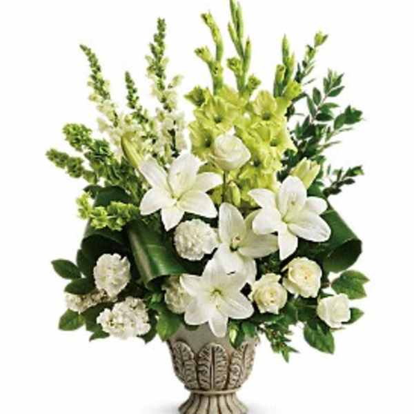 White lilies and green flowers arranged in a decorative urn