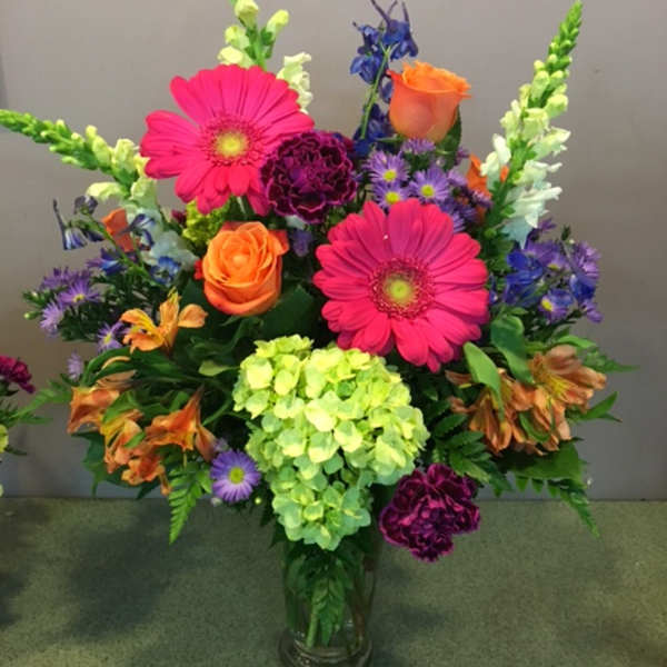 Colorful mixed flower arrangement in a clear glass vase