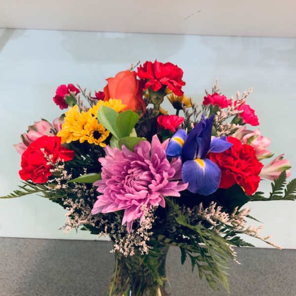 Mixed bouquet of colorful flowers in a clear glass vase