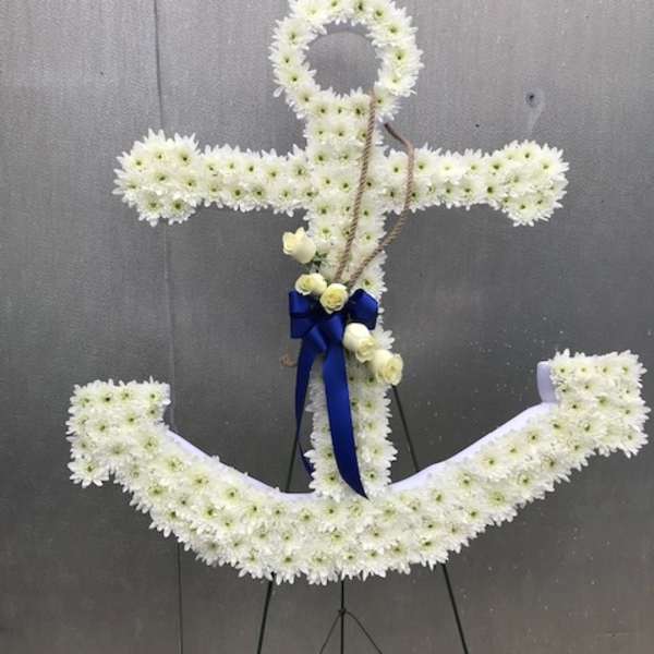 Anchor-shaped standing spray of white flowers with blue ribbon and rope accent.