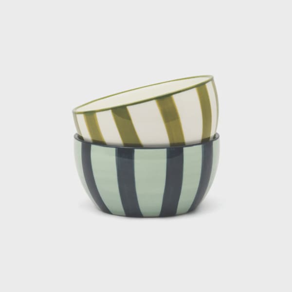 Two striped ceramic bowls stacked together on a white background