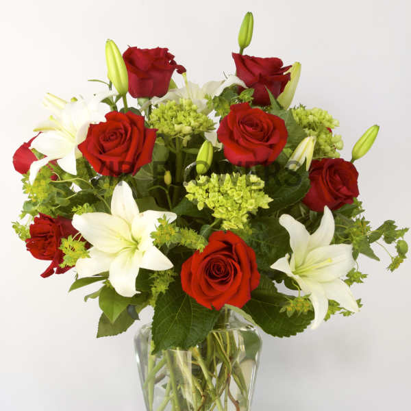 Red roses and white lilies in a clear glass vase