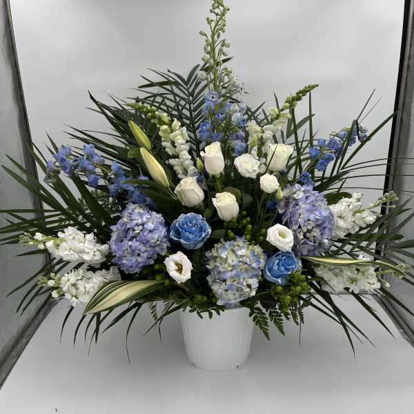 Blue and white floral arrangement in a white vase