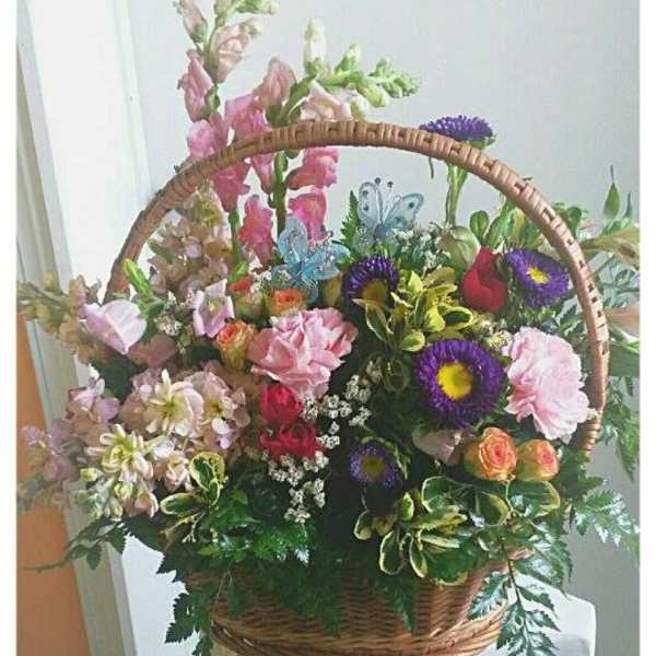 Basket arrangement of mixed pink, purple, and orange flowers