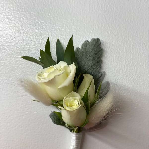 Small white rose boutonniere with gray foliage and soft feather accents
