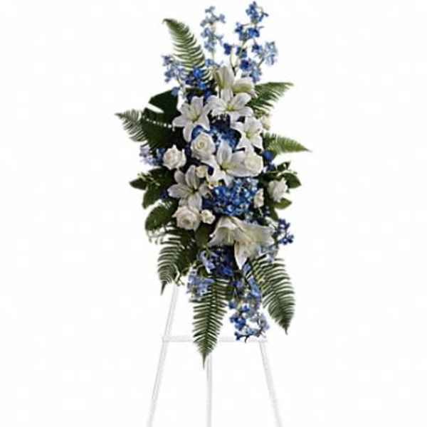 Tall white and blue floral standing spray on an easel