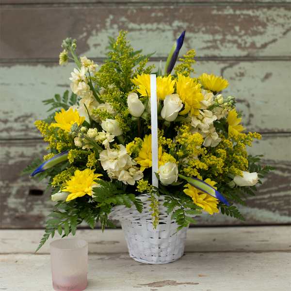 Yellow and white flower basket with a white candle