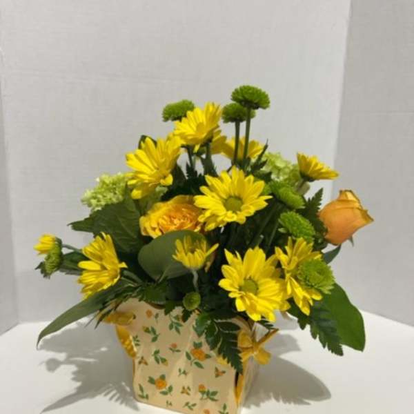 Yellow daisy bouquet in a floral paper box