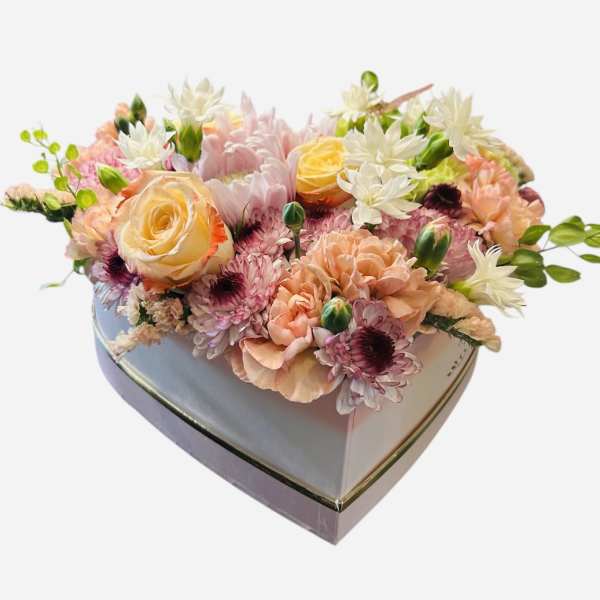 Heart-shaped box filled with pastel mixed flowers