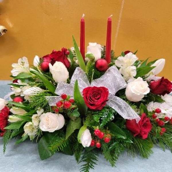Red and white floral centerpiece with candles and a silver bow