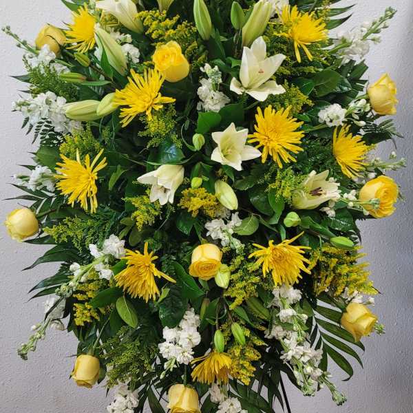Large yellow and white floral standing spray on an easel