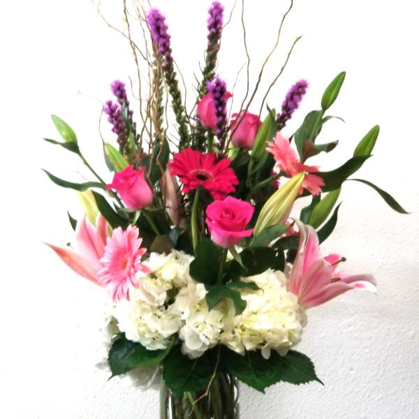 Tall mixed bouquet in a clear glass vase with pink and white flowers
