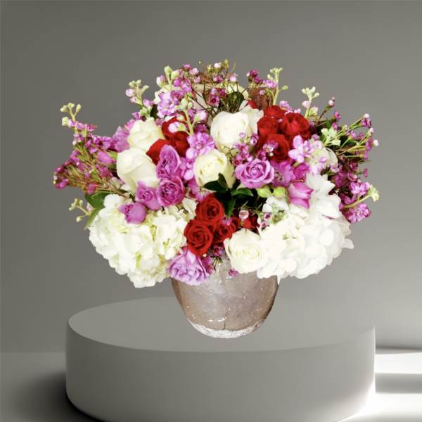 Mixed roses and hydrangeas in a round vase