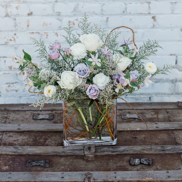 Pastel flower arrangement in a square glass vase